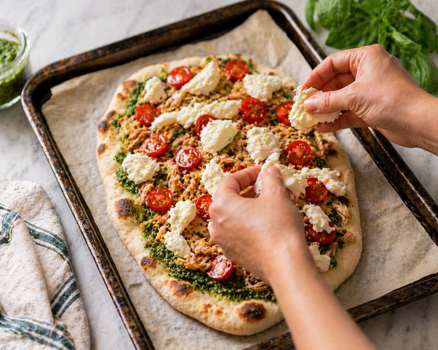 Flatbread topped with shredded chicken, cherry tomatoes and torn fresh mozzarella — ready to bake