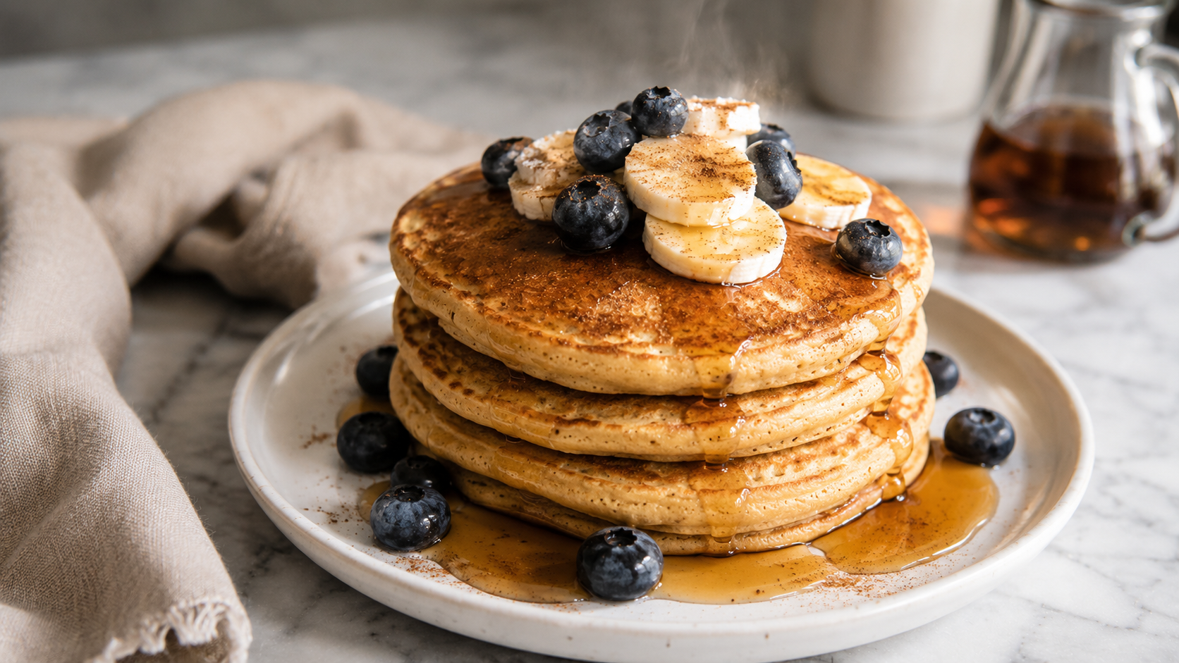 Finished protein pancakes stacked and topped with fresh berries and a drizzle of honey