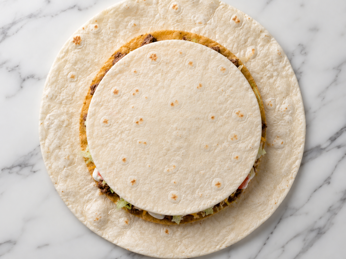 Small 6-inch flour tortilla placed in the center on top of the toppings to fill the gap for folding