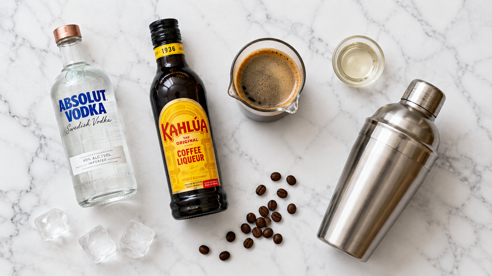 Espresso martini ingredients laid out — vodka, espresso, Kahlúa, simple syrup and coffee beans