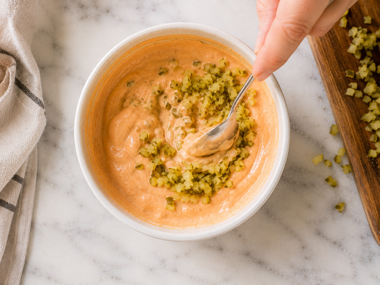 Stirring in finely chopped dill pickles for extra texture — optional but highly recommended