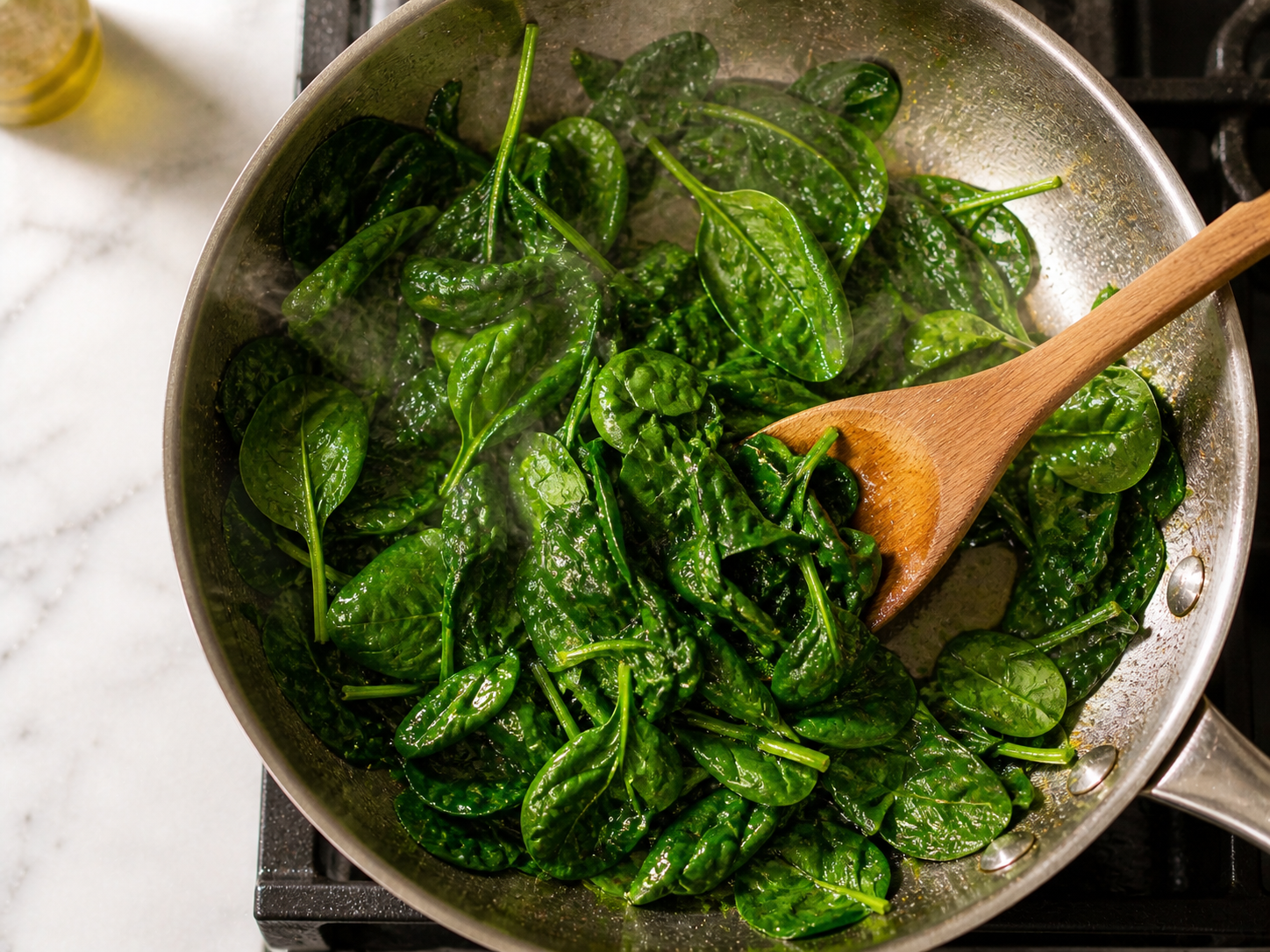 Baby spinach wilting in the same skillet — bright green and just tender after 90 seconds