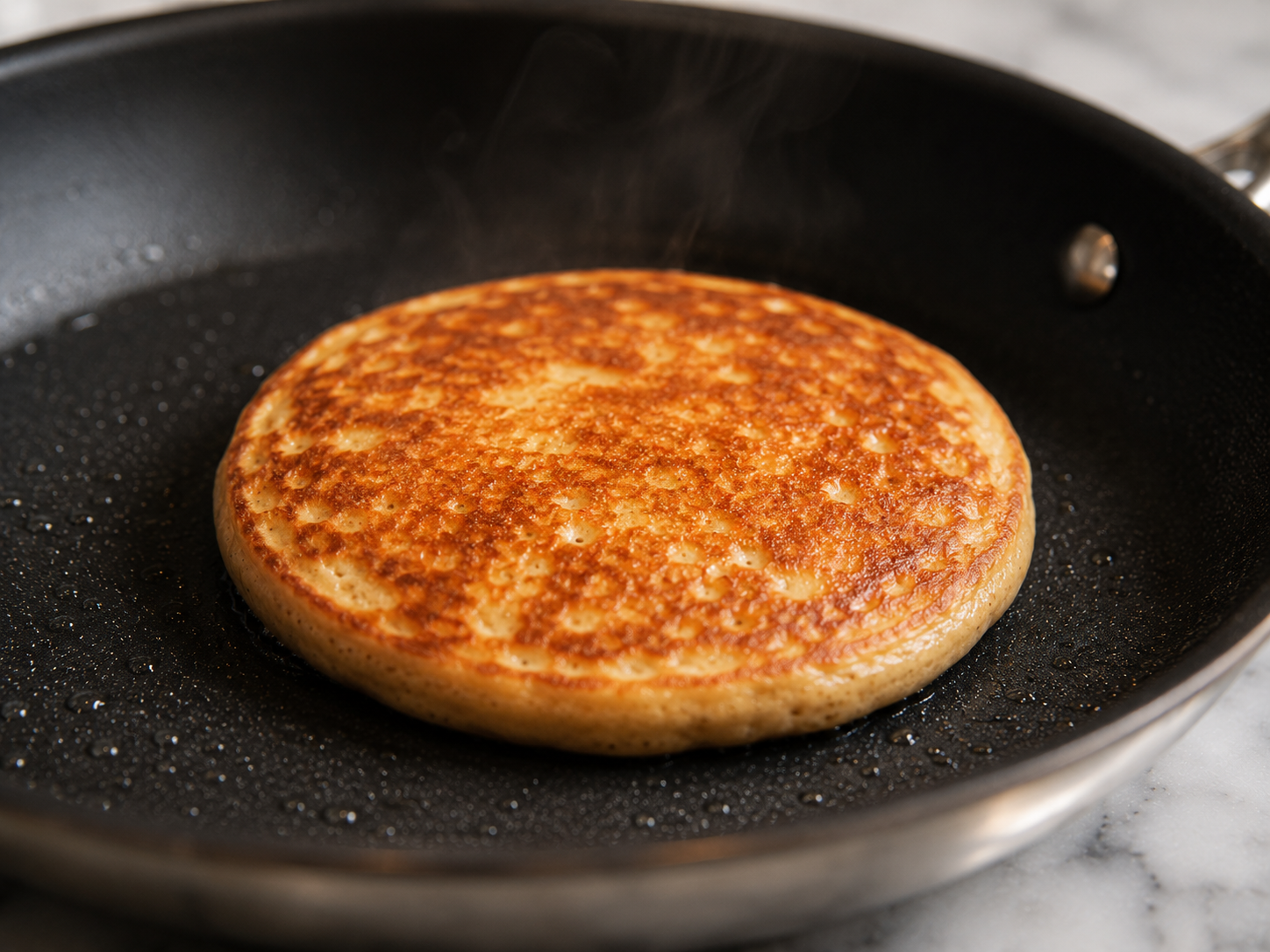 Protein pancake flipped — golden brown on both sides in the skillet
