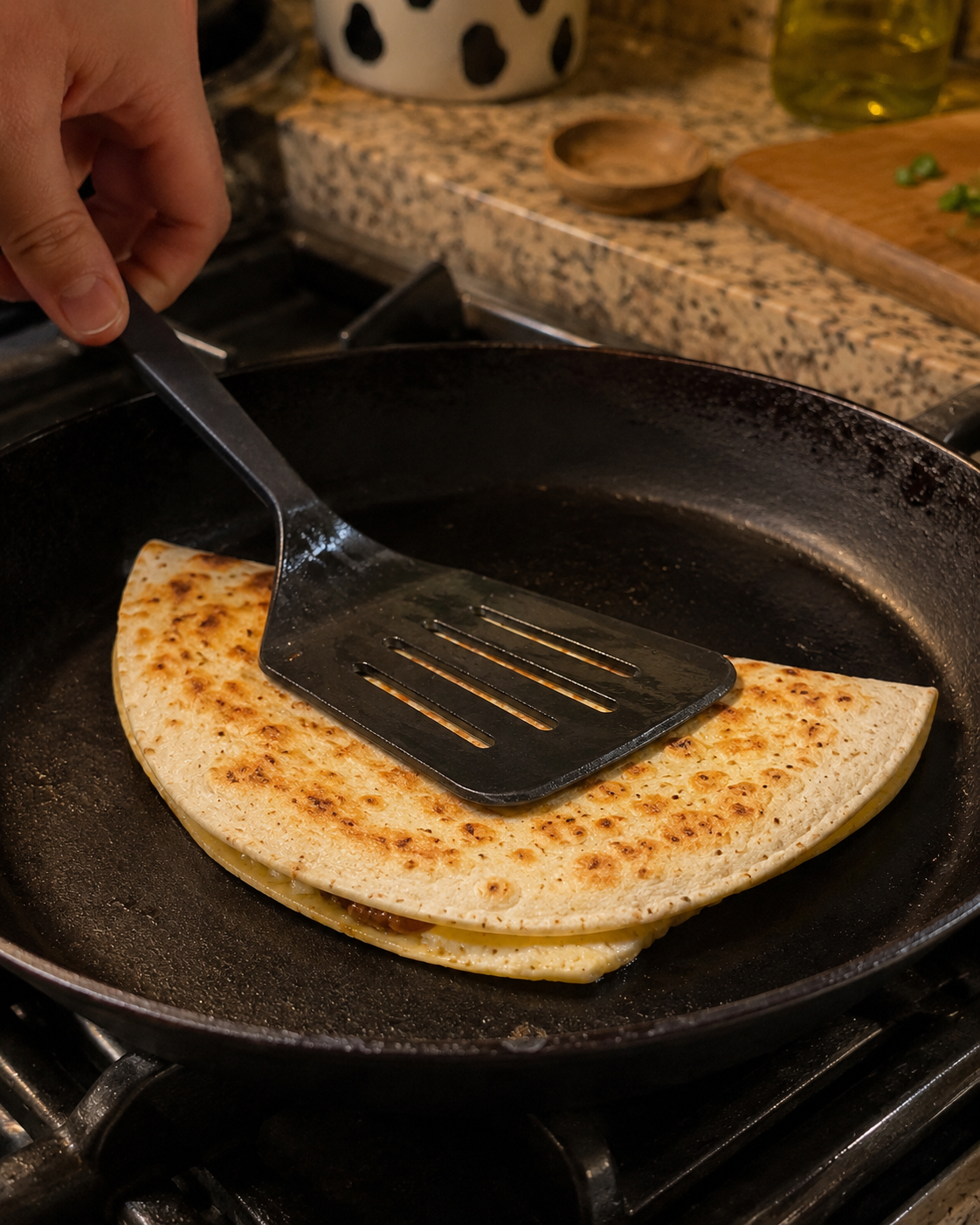 Folded quesadilla cooking in a dry skillet over medium heat — golden and crispy on both sides