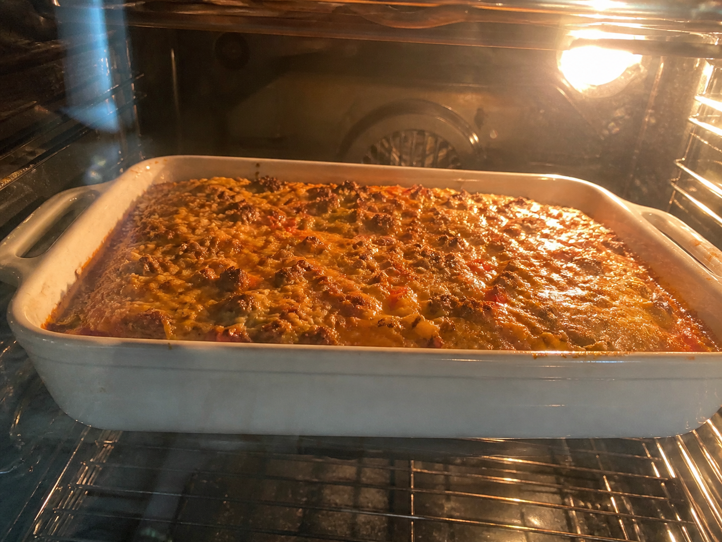 Breakfast casserole baking in the oven — uncovered for the final stretch, top golden and bubbling