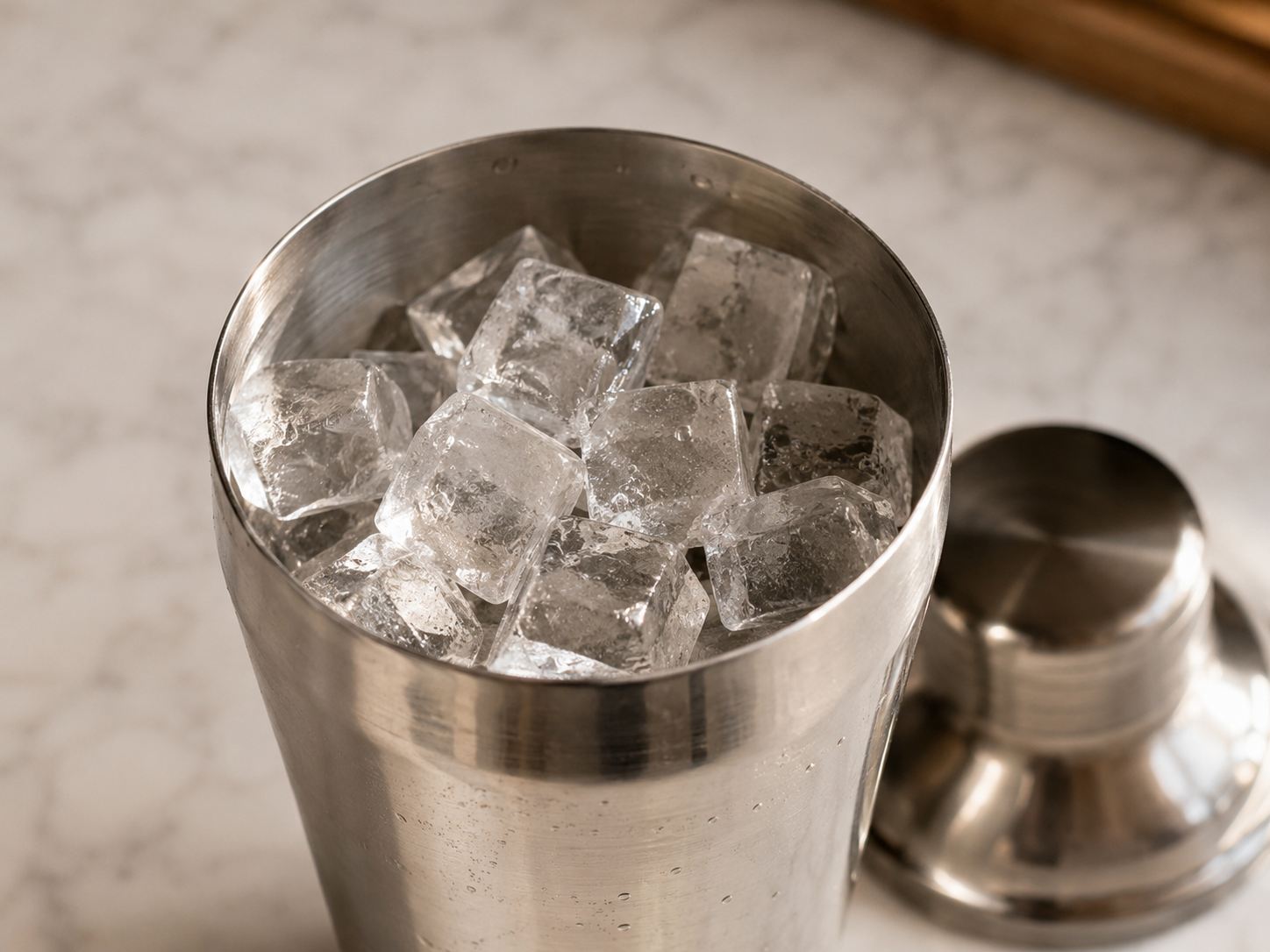Cocktail shaker packed generously with ice — ready for the espresso martini ingredients