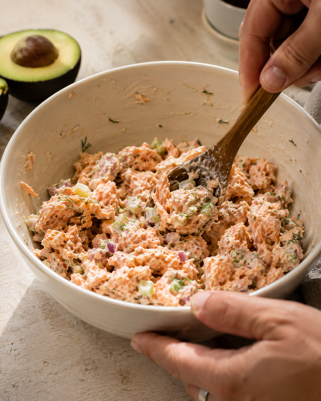 Folding salmon into the creamy dressing — keeping the texture chunky