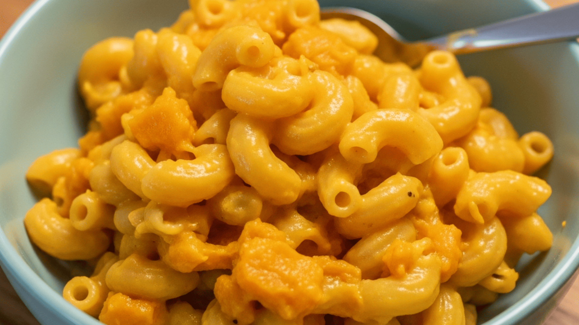 Creamy butternut squash mac and cheese in a kid's bowl, warm kitchen lighting