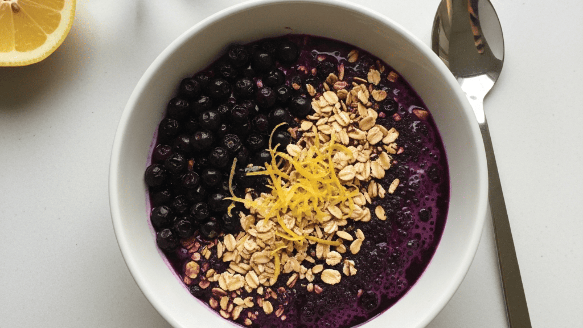 Near-indigo wild blueberry bowl with toasted oats and lemon zest