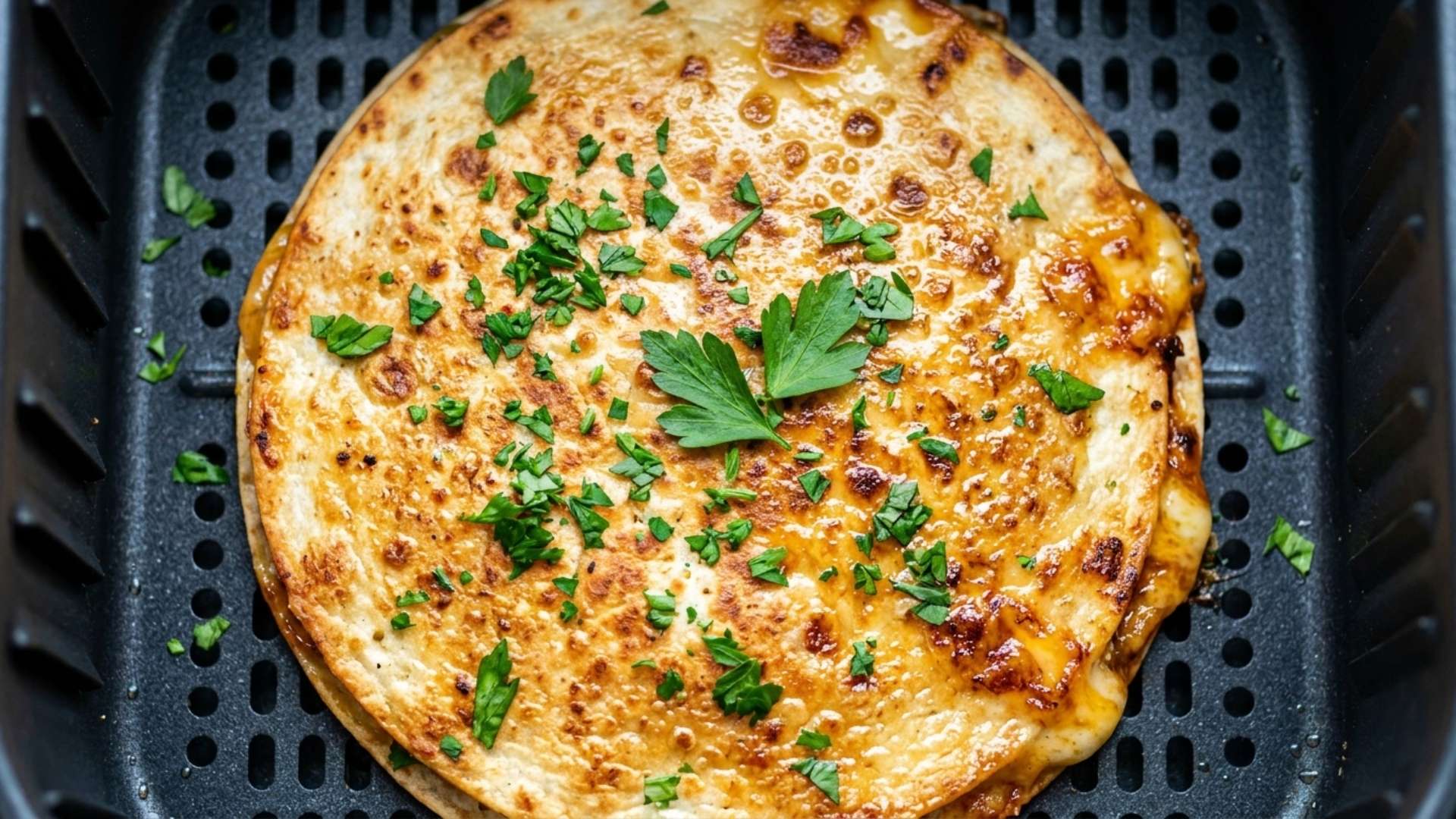 Golden quesadilla cut into wedges with salsa and guacamole on a wooden board