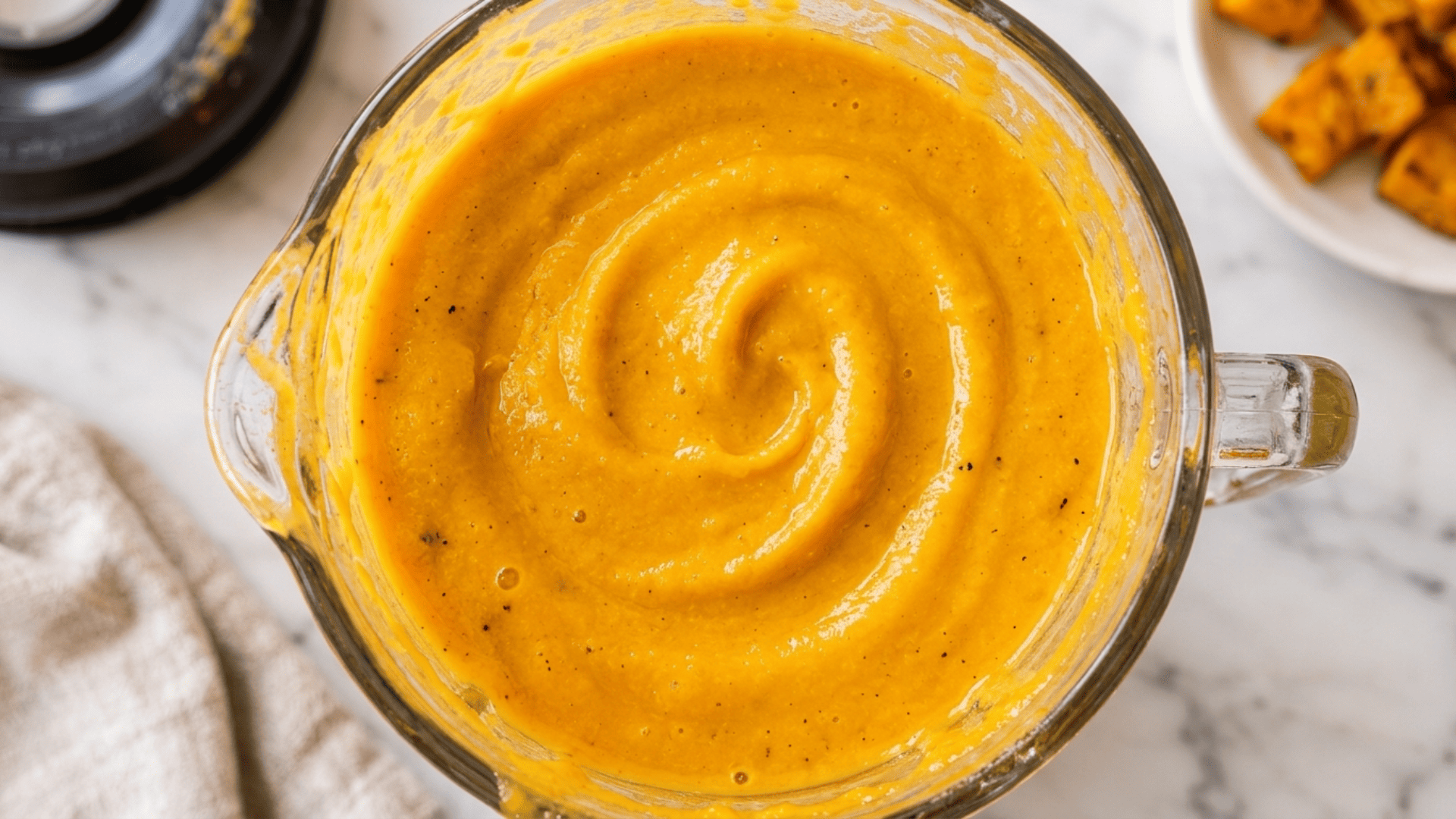 Silky blended butternut squash sauce in a blender, smooth and bright orange