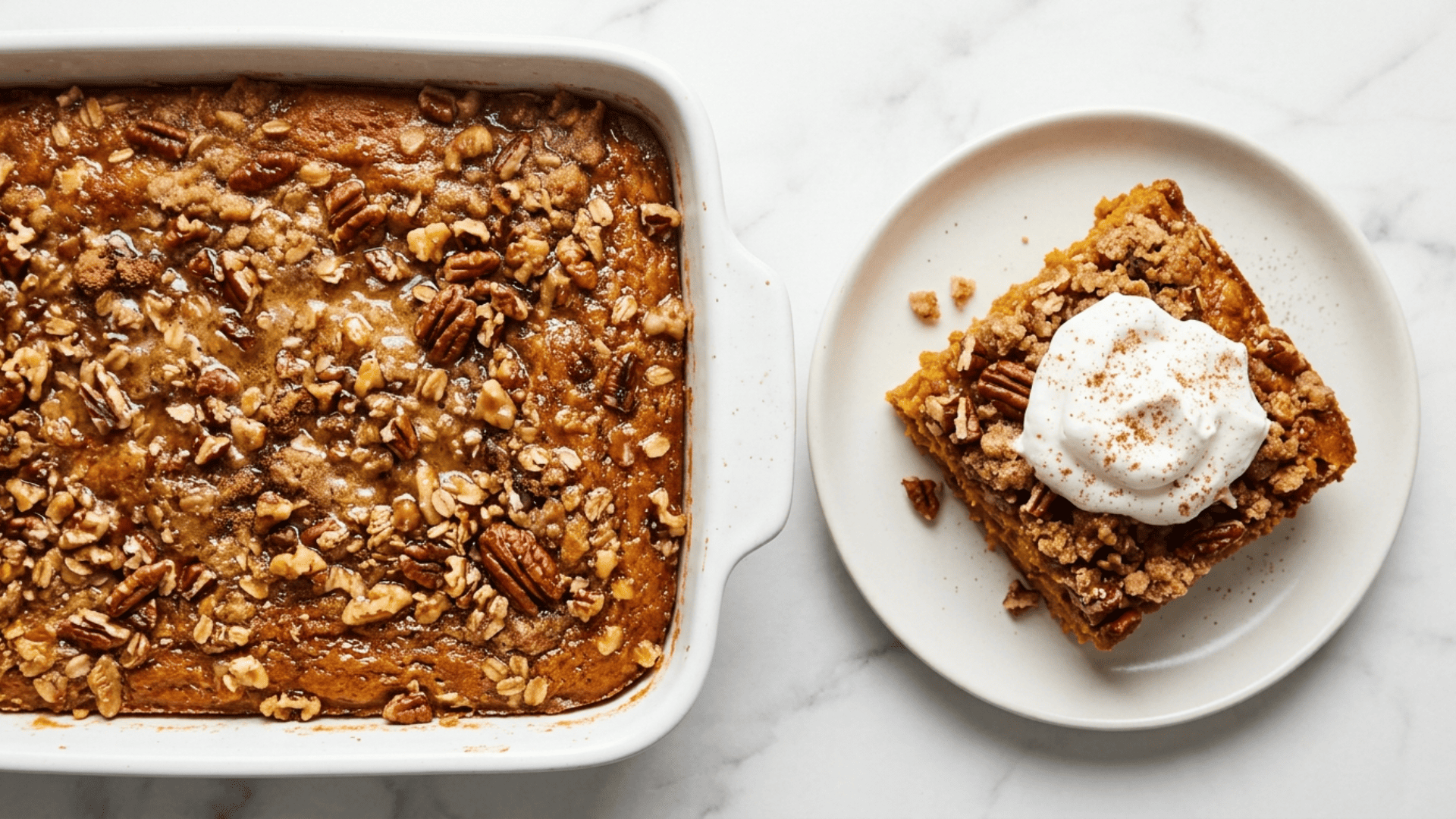 Warm pumpkin dump cake in a white baking dish with a golden buttery top, a scoop of vanilla ice cream melting on one serving