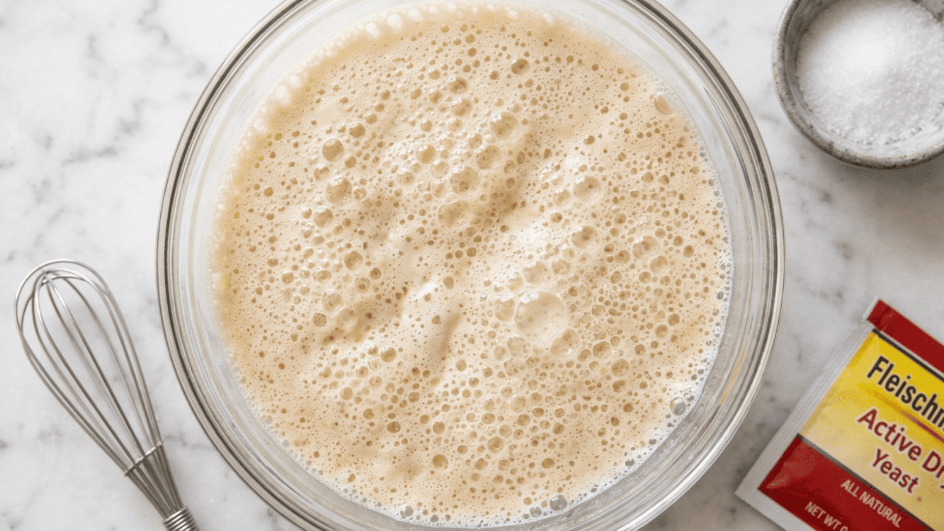 Foamy yeast and warm milk mixture in a glass bowl