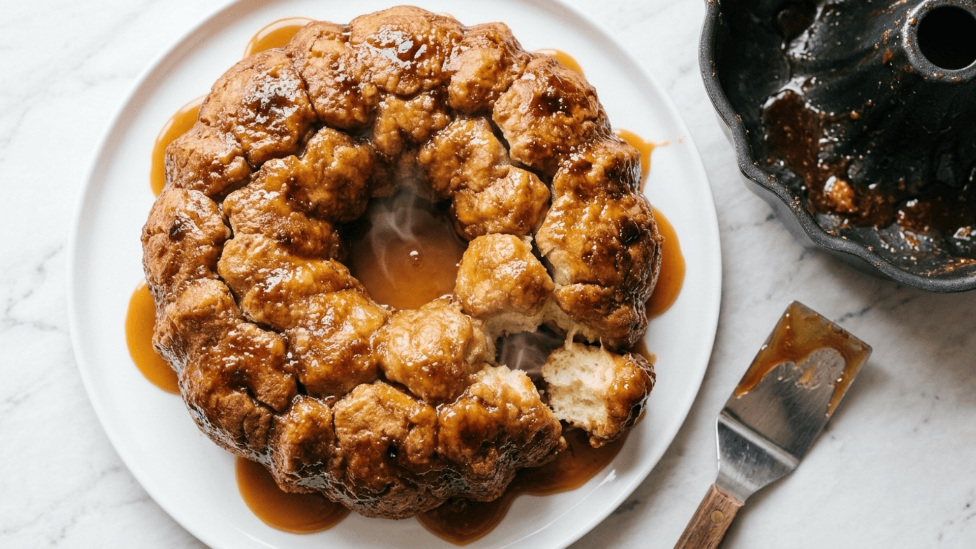 Gooey caramel monkey bread on a plate with pieces pulled apart