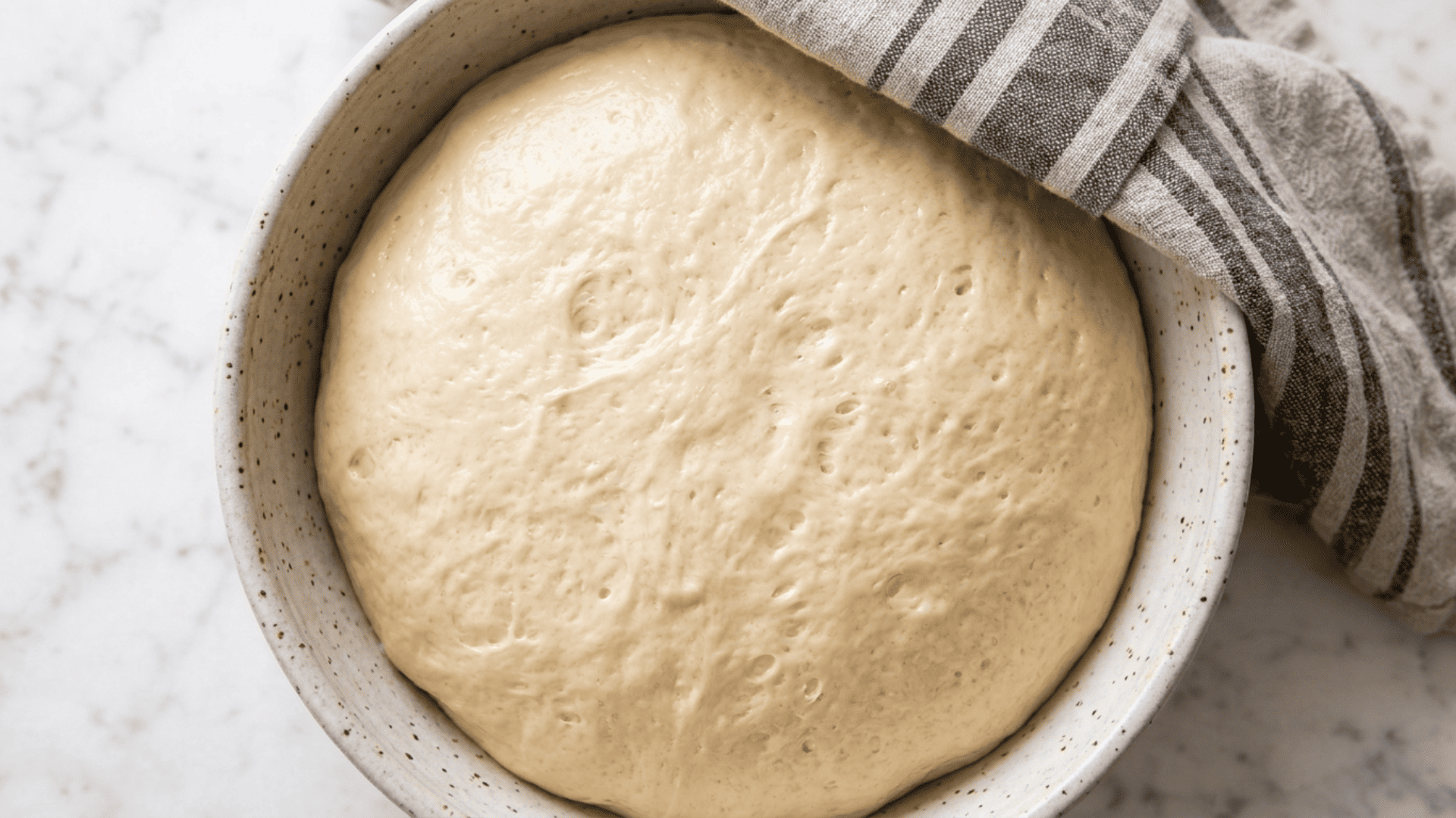 Monkey bread dough doubled in size in a greased mixing bowl