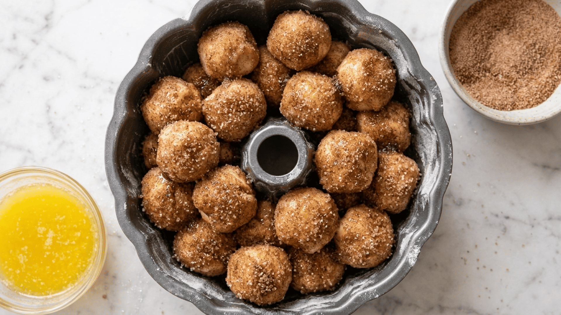 Cinnamon sugar coated dough balls layered loosely in a bundt pan