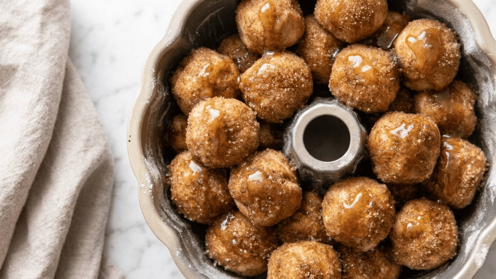 Puffy monkey bread dough balls filling the bundt pan after the second rise