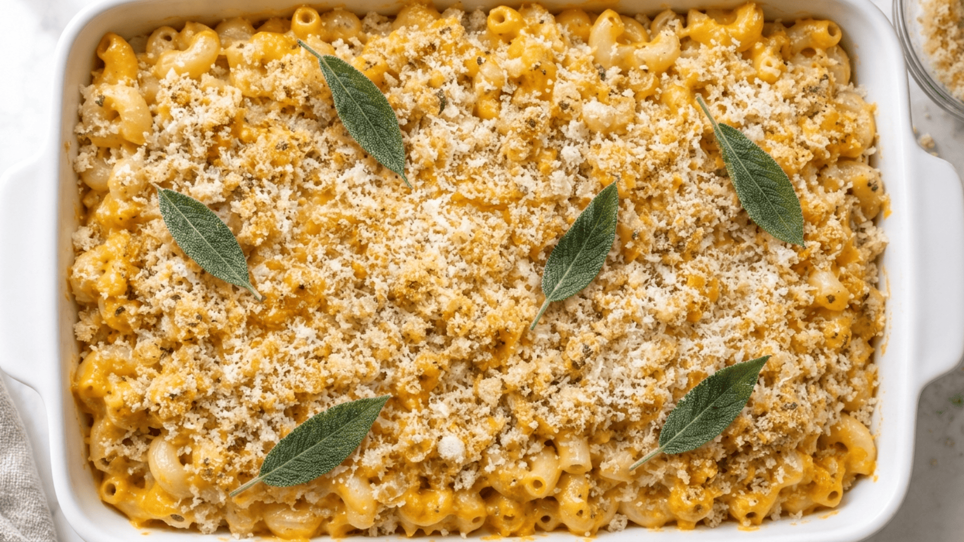 Buttery panko and parmesan topping sprinkled over mac and cheese with fresh sage leaves